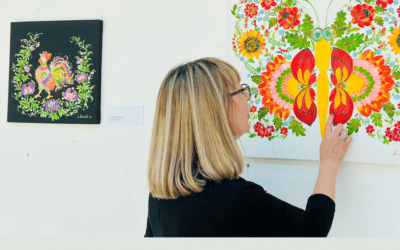 Ukrainian journalist and artist Lyudmila Makei examines a painting of flowers